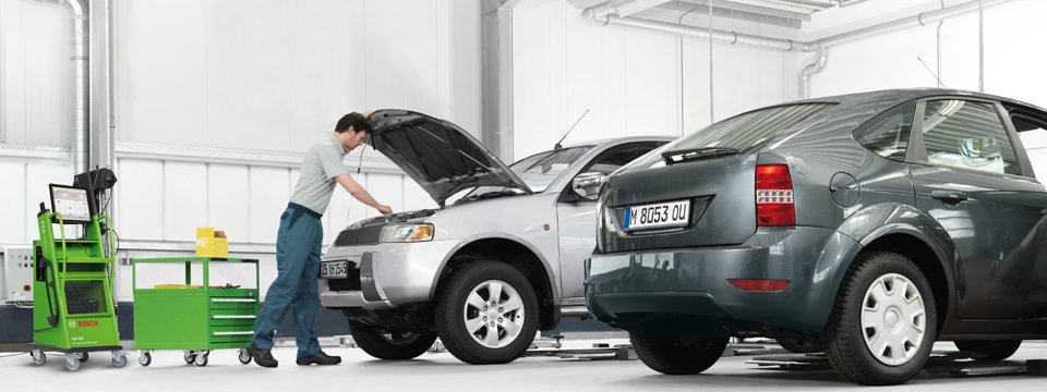 Fotografia demonstrando tecnico de mecacina bcs reparando un auto con el cofre abierto.